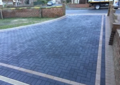Dark block paved driveway with light border design