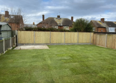 Freshly laid turf lawn with new wooden fencing in garden