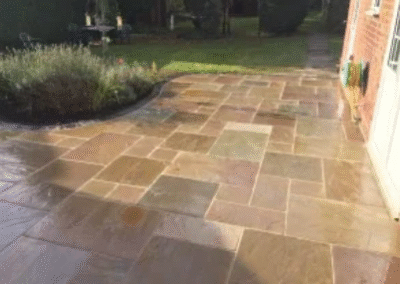 Natural stone patio with clean finish beside garden lawn