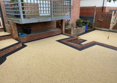 Resin bound patio with brick edging and raised garden area
