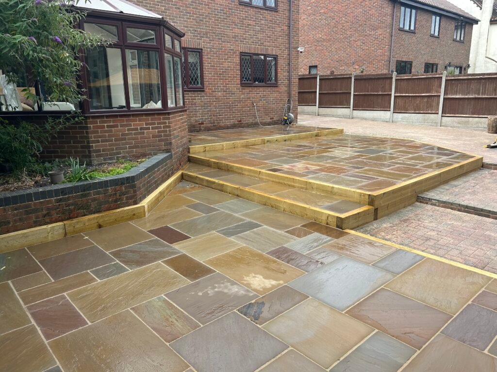 Newly installed multi-level natural stone patio with timber risers