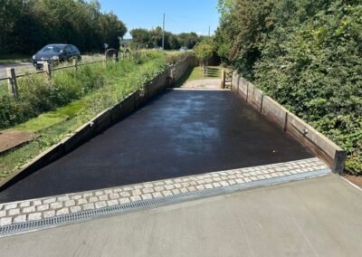 Tarmac path beside a road leading down to a gravel track