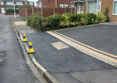 Fresh tarmac on pavement in front of a new driveway