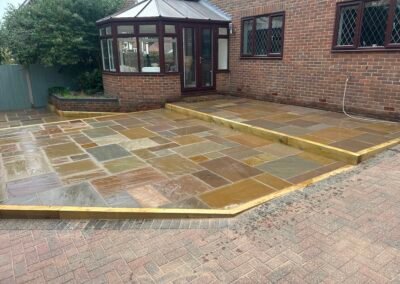 Newly installed multi-level natural stone patio with timber risers