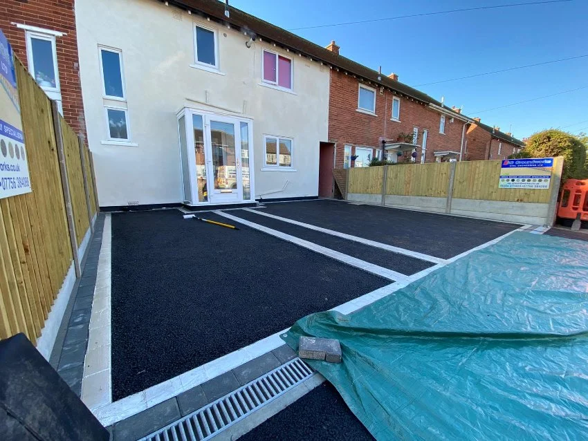 Newly installed tarmac driveway with marked parking bays at a residential property