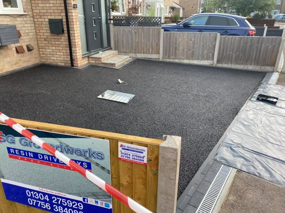 Black resin driveway installation outside house