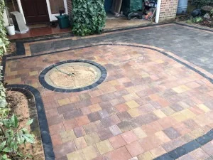 Block paved residential driveway with decorative edging and circular paving feature